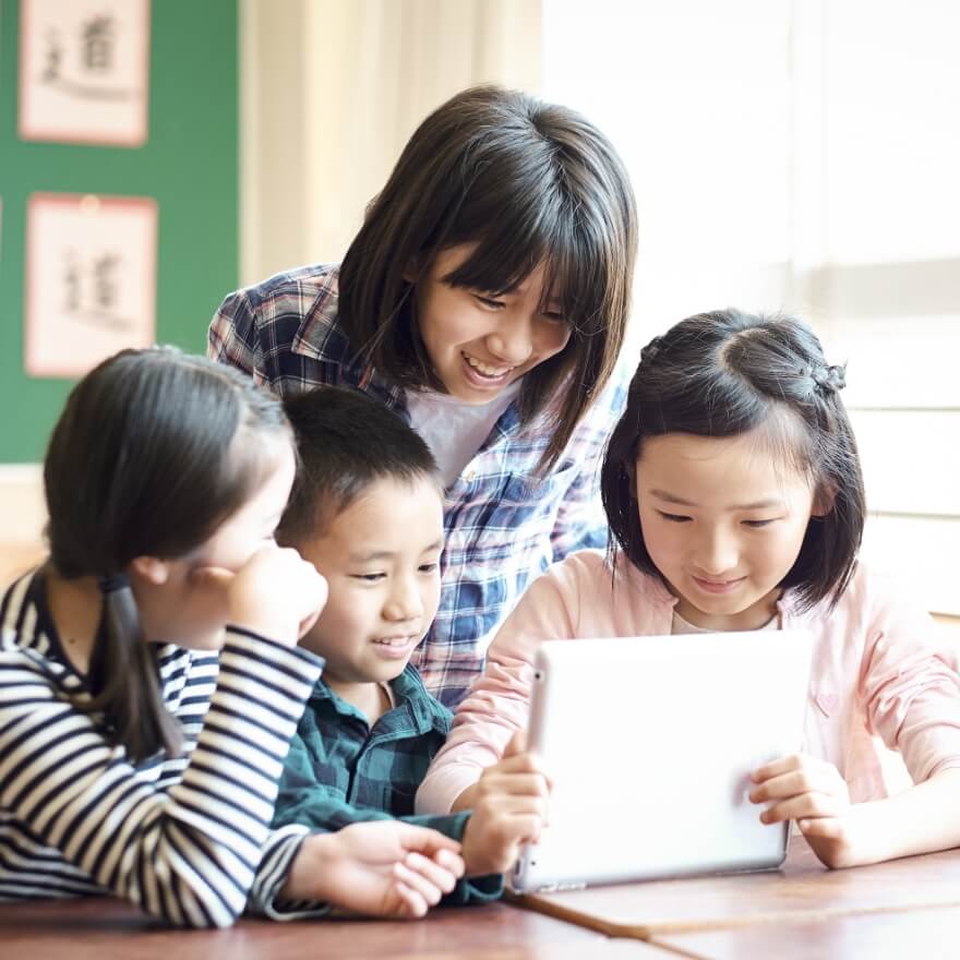 タブレットを覗き込む子供たち