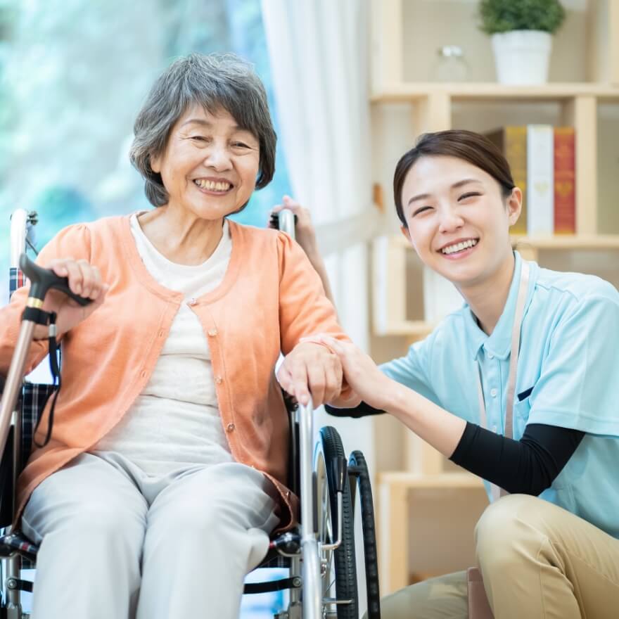 車いすに座った年配の女性と職員